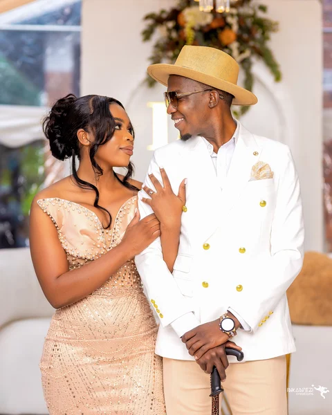 A lobola wedding couple smiling at each other in gold and cream outfits